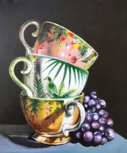 Oil painting of 3 stacked tea cups and bunch of grapes
