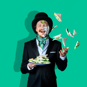 Photo of man in top hat and tails throwing cucumber sandwiches